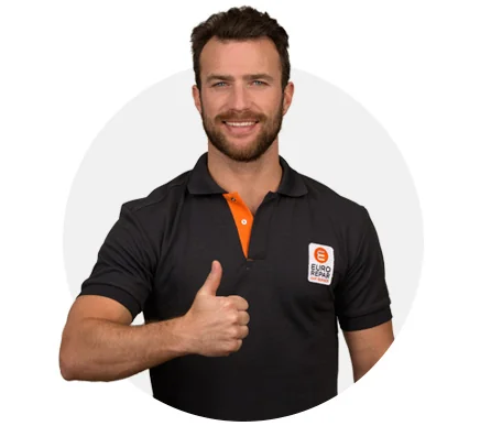 Homme souriant en polo Eurorepar faisant un pouce levé, symbole de satisfaction client et de service de qualité.
