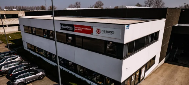 Buitenzicht op het gebouw van Belgian Car Parts en Distrigo in Zwevegem met logo’s, als verdeler van auto-onderdelen.